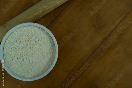 A bowl of flour on a wooden table, World Flour day and cooking concept Selective focus