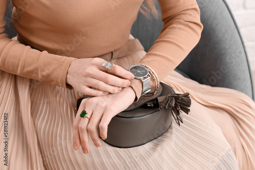 Woman with stylish wristwatch sitting at home, closeup