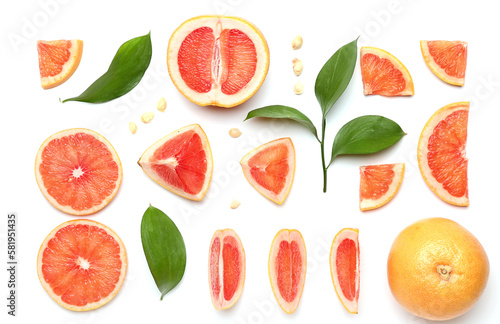 Composition with pieces of ripe grapefruit, seeds and plant leaves on white background