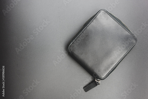 The zippered wallet with leather on a black background. Top view