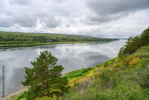 View of the Tom River in the Siberian taiga under a stormy sky in summer