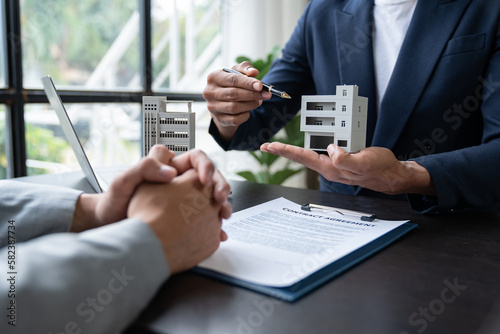 Entrepreneur, business owner, accountant, real estate agent A young Asian insurance agent explains the details of the condo purchase contract to calculate the financial risk for the client.