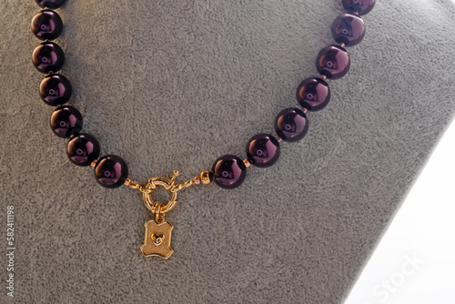 author beautiful blackberry color pearls necklaces with heart pendant demonstrated on maneken. fashion and jewelry concept