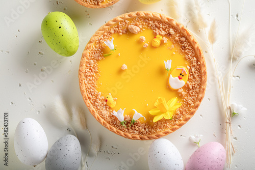 Tasty Mazurka cake surrounded by spring flowers and eggs.