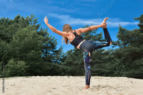 Joga, młoda dziewczyna, kobieta praktykująca jogę w parku. Pozycje jogi, asany, ćwiczenia rozciągające, sport na powietrzu. Yoga, young woman practicing yoga in the nature. 
