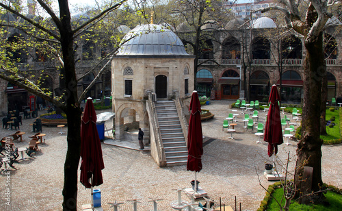Courtyard view of the two-story Koza Han market with shops and a mosque in the center in Bursa, Turkey