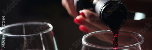 Woman pouring red wine into glass, tasting and degustation