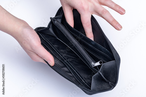 Czarny portfel trzymany w damskich dłoniach pusty w środku 