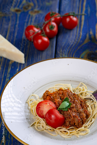italian Pasta bolognese with meat, tomato sauce and vegetables in blue wooden desk .