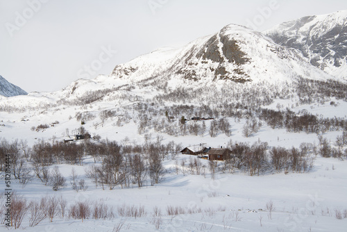 Schöne Winterlandschaft mit Hütten bei Gjendersheim in den Bergen von Jotunheimen, Norwegen