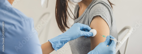 People getting a vaccination to prevent pandemic concept. Woman in medical face mask receiving a dose of immunization coronavirus vaccine from a nurse at the medical center hospital