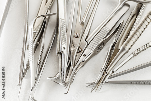 Surgical ophthalmological precision narrow metal instruments on white background, selective focus