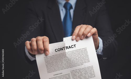 Canceled contract. Businessman is tearing up a contract while standing in the office