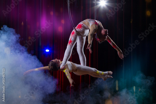 Circus acrobats gymnasts perform on a stage dark background.