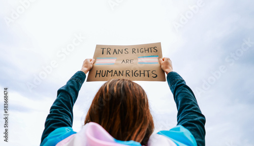 Transgender woman fighting for trans human rights at gay pride protest holding banner - People celebrating LGBTQ event concept