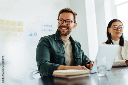 Happy business man listening to a discussion in an office