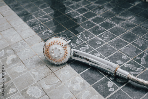 Silver shower head with limescales. Shower damaged from water scale.