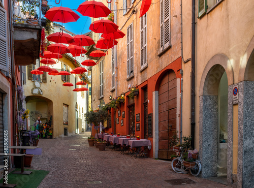 cobblestone street with small shops and colorful decorations in the old city center of Luino