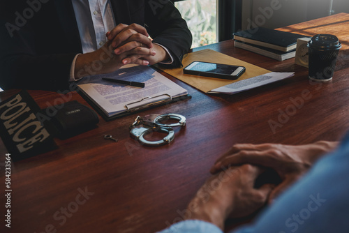 Law enforcement officer interrogating Criminals male with handcuffs in the investigation room Police officer interviewing after committed a crime