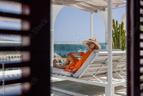 smiling woman relaxing in sunbed and enjoy the summer vacation at luxury villa terrace with seaview