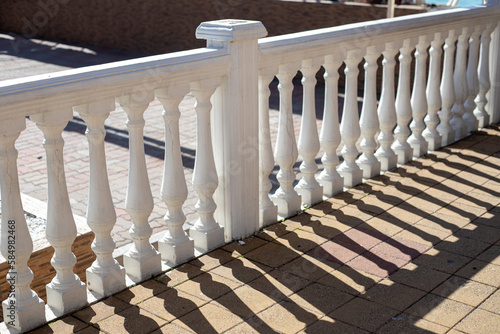 Row of white concrete balusters on the embankment close-up