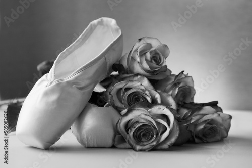 new ballet slippers lying with roses. elegant ballet shoes bouquet. dance black and white image