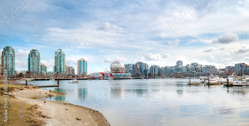 Touristic waterfront city panorama on a sunny spring day with modern highrise buildings, anchored boats and Science World. False Creek, Vancouver, BC, Canada. Selective focus.