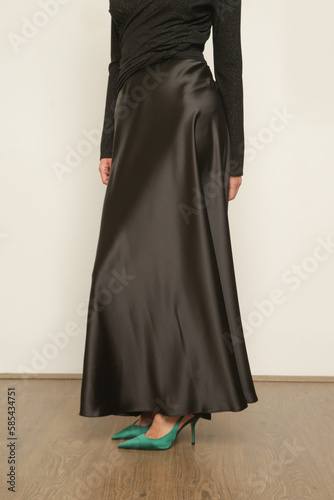Serie of studio photos of young female model wearing maxi black silk skirt with black wrapped blouse