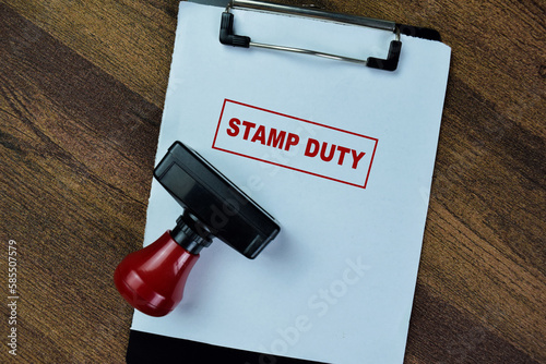 Concept of Red Handle Rubber Stamper and Stamp Duty text isolated on on Wooden Table.