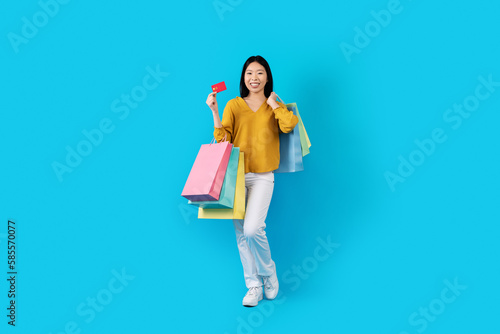 Pretty chinese woman enjoying easy shopping with bank card