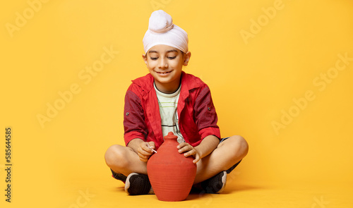 Indian happy Sikh child with piggy bank investment concept