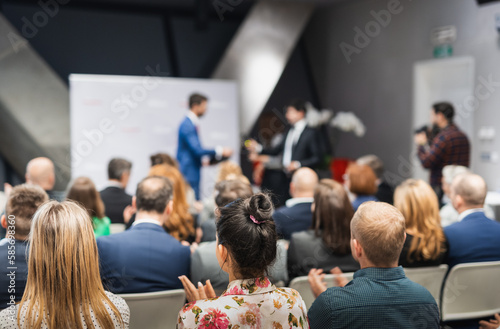 Business team leader receiving award prize at best business project competition event. Business and entrepreneurship award ceremony theme. Focus on unrecognizable people in audience