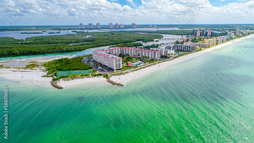 Drone Aerial View of Real Estate on Little Hickory Island in Bonita Spring, Florida with Gentle Wave Water in the Foreground and Bay Surrounded by Mangroves in the Background