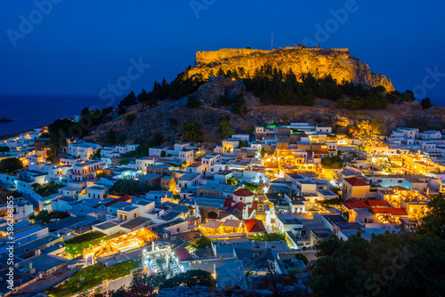 Sunset view of Acropolis of Lindos overlooking traditional white houses at Rhodes island, Greece