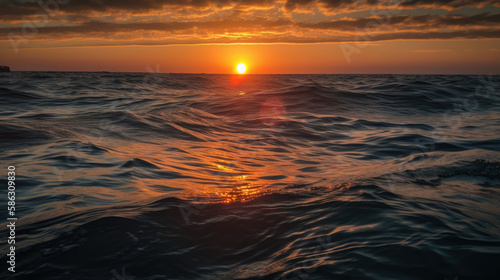 sunset over the ocean, calm and blue ocean waves and ripples, sun is setting on the horizon (created with Generative AI)