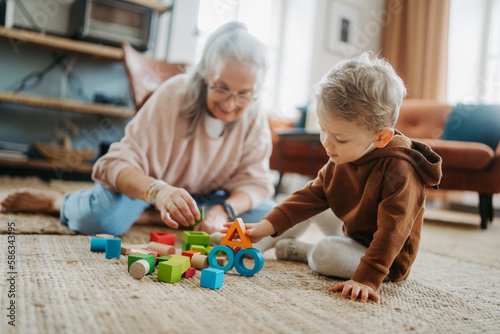 Grandmother playing with her little grandson,building a block set.