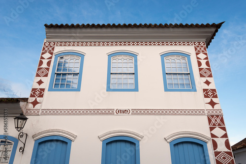 Paraty, Brazil. Facade of a colonial house from 1836 in white and blue colors. Background blue sky.