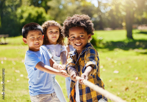 Fun, games and kids playing tug of war together outdoor in a park or playground in summer. Friends, diversity and children pulling a rope while being playful fun or bonding in a garden on a sunny day