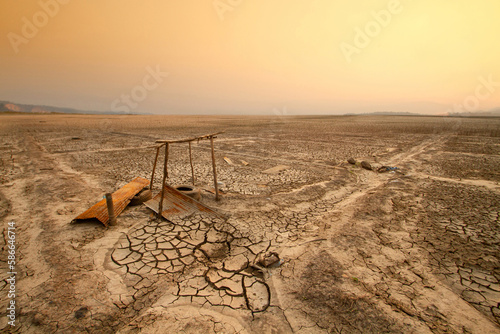 Old hand water pump at middle dry cracked earth. By el nino effect long term Droughts impact agricultural. Climate change and World temperature crisis concept.