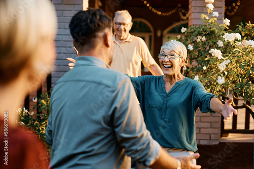 Cheerful senior woman greets her son who came to visit.