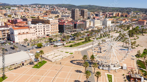 Aerial view of the Ferris wheel located on the waterfront of Civitavecchia in the Metropolitan City of Rome, Italy. On the city's waterfront there is a park and residential buildings.