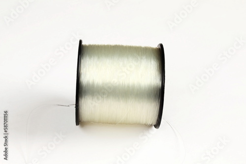 spool of transparent nylon thread can be used to make jewelry,clothing,craft or fishing line,white background with copy space