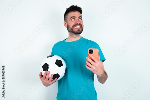 Young man holding a ball over white background holding in hands showing new cell