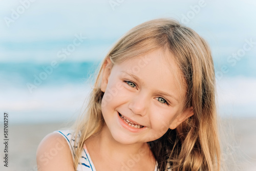 sunny summer day near the sea excited happy smiling face portrait adorable child toddler girl in blue dress