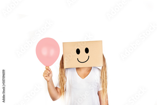 Mujer sonriente con una caja de cartón en la cabeza sosteniendo un globo rosa pastel sobre un fondo blanco liso y aislado. Vista de frente y de cerca. Copy space