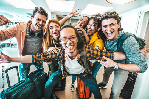 Group of young tourists standing in youth hostel guest house - Happy multiracial friends booking summer vacation home - Guys and girls having fun taking selfie picture at summertime holidays