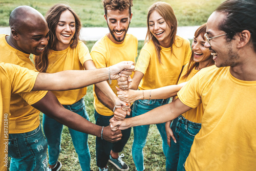 Multiracial happy young people stacking hands outside - Youth community concept with guys and girls standing together supporting each other .