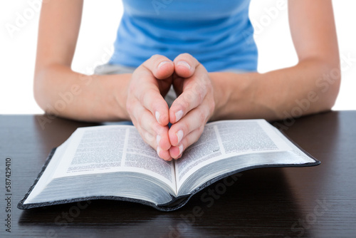 Woman praying while reading bible