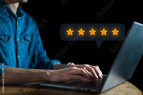 User give rating to service experience on online application for Customer review satisfaction feedback survey concept. 5 stars rating satisfied client. Dark background. Business concept on laptop