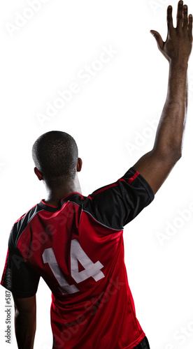 Rear view of sportsman posing while playing volleyball